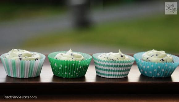 row of four vegan peppermint patty brownie cupcakes with green cupcake wrappers